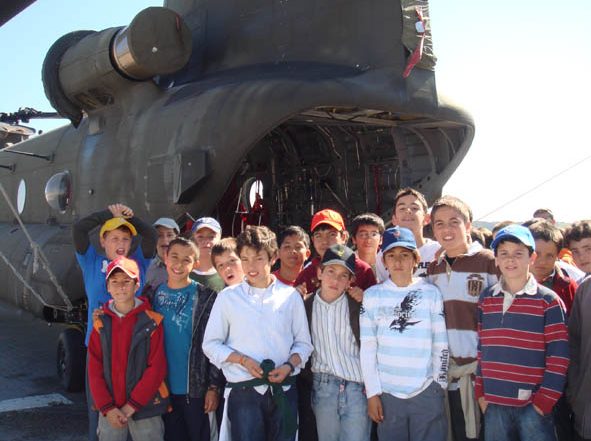 Alumnos delante de un helicóptero en la base